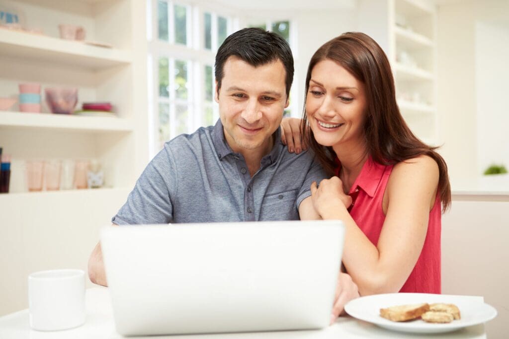 Happy couple looking at a sheet of paper in the comfort of their home