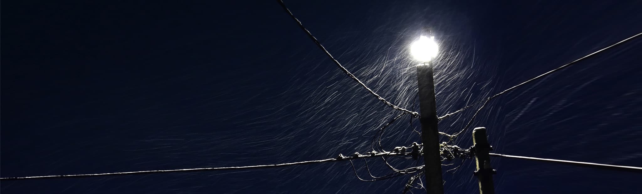 Lit up light post in the middle of a rainy night