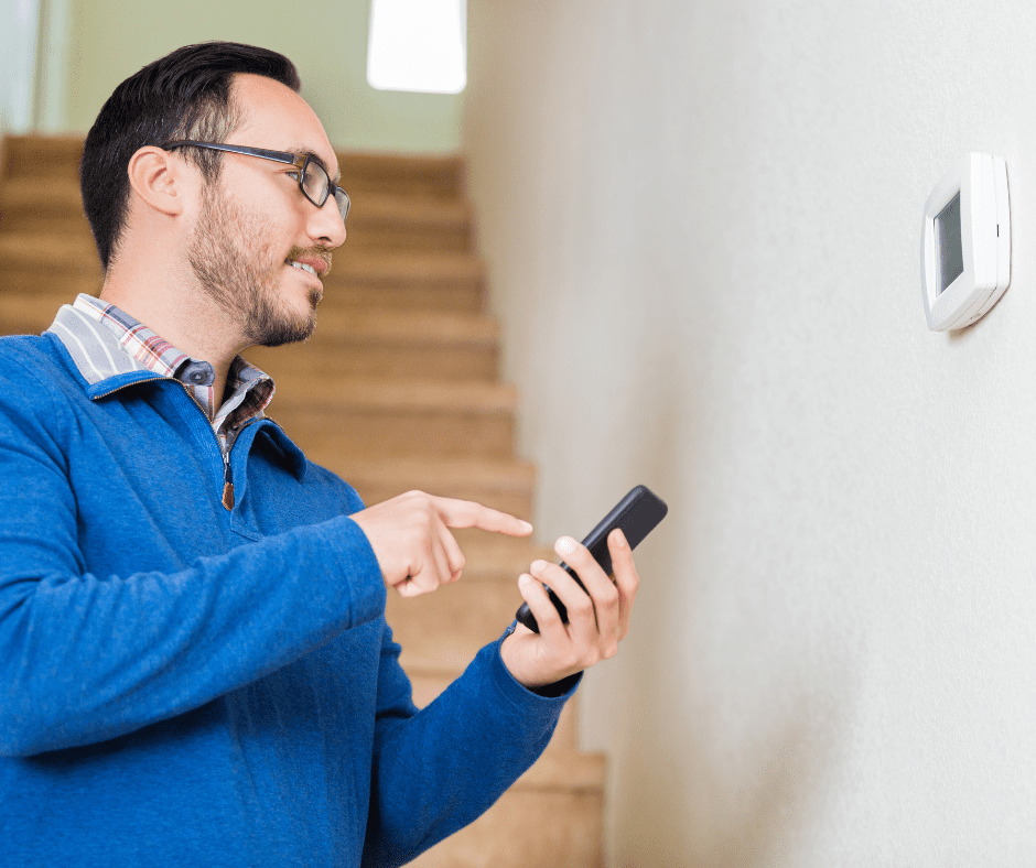 man setting thermostat