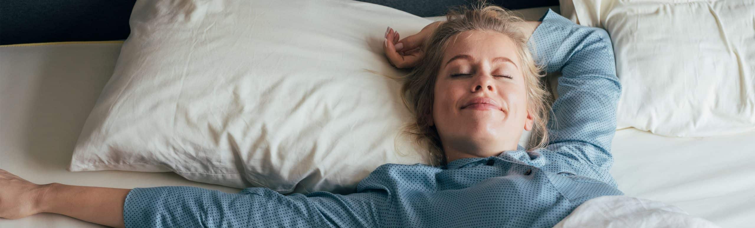 Person laying in bed with a smile on her face