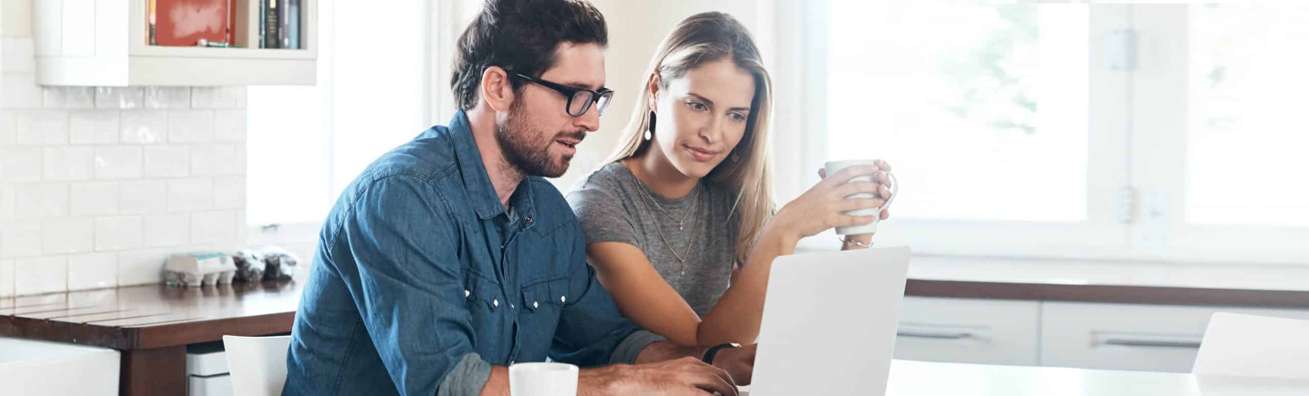 Man and woman sitting and looking at a laptop