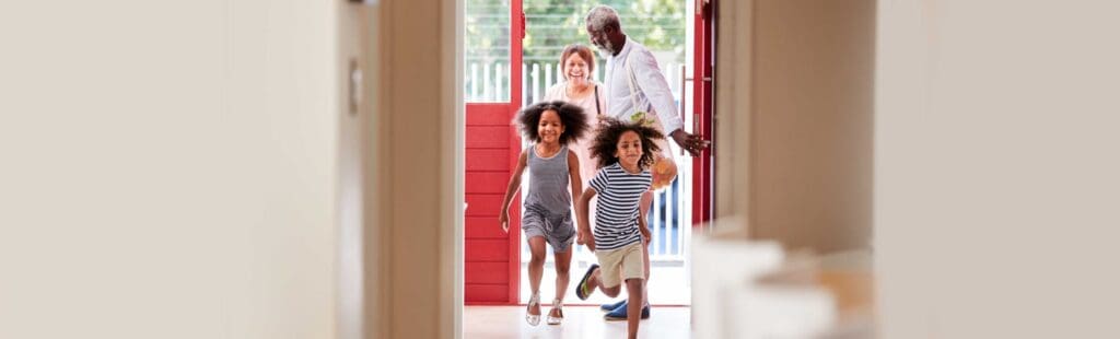 Family opening the front house door and walking/running inside