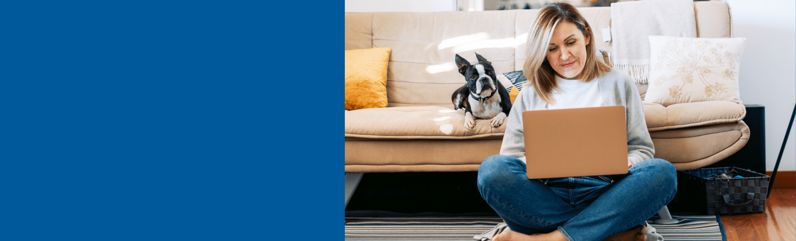 wpman sits on floor crosslegged looking at her laptop