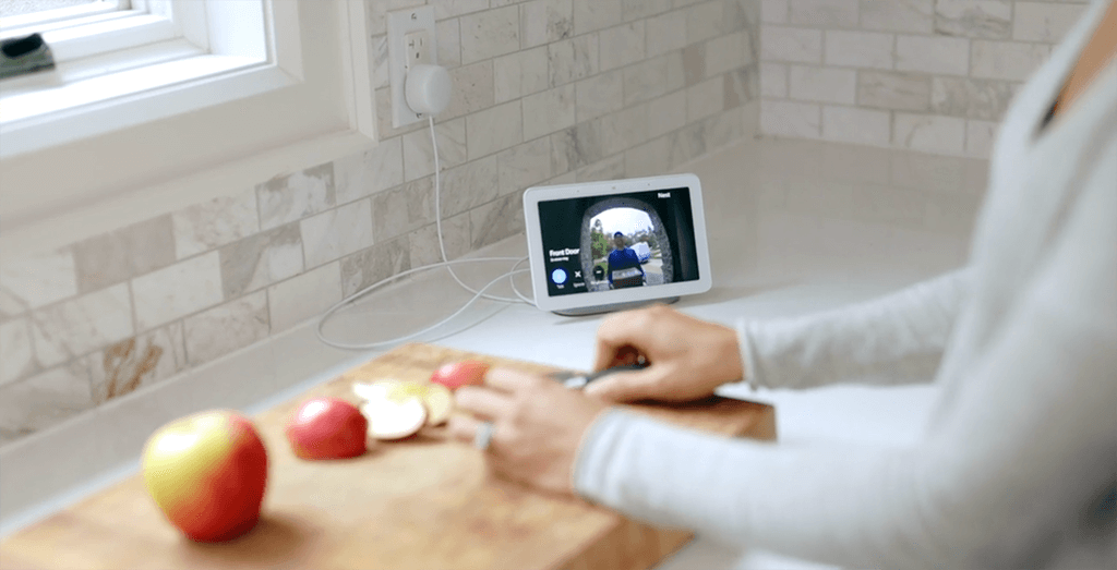 Cutting fruits while checking the smart home monitor