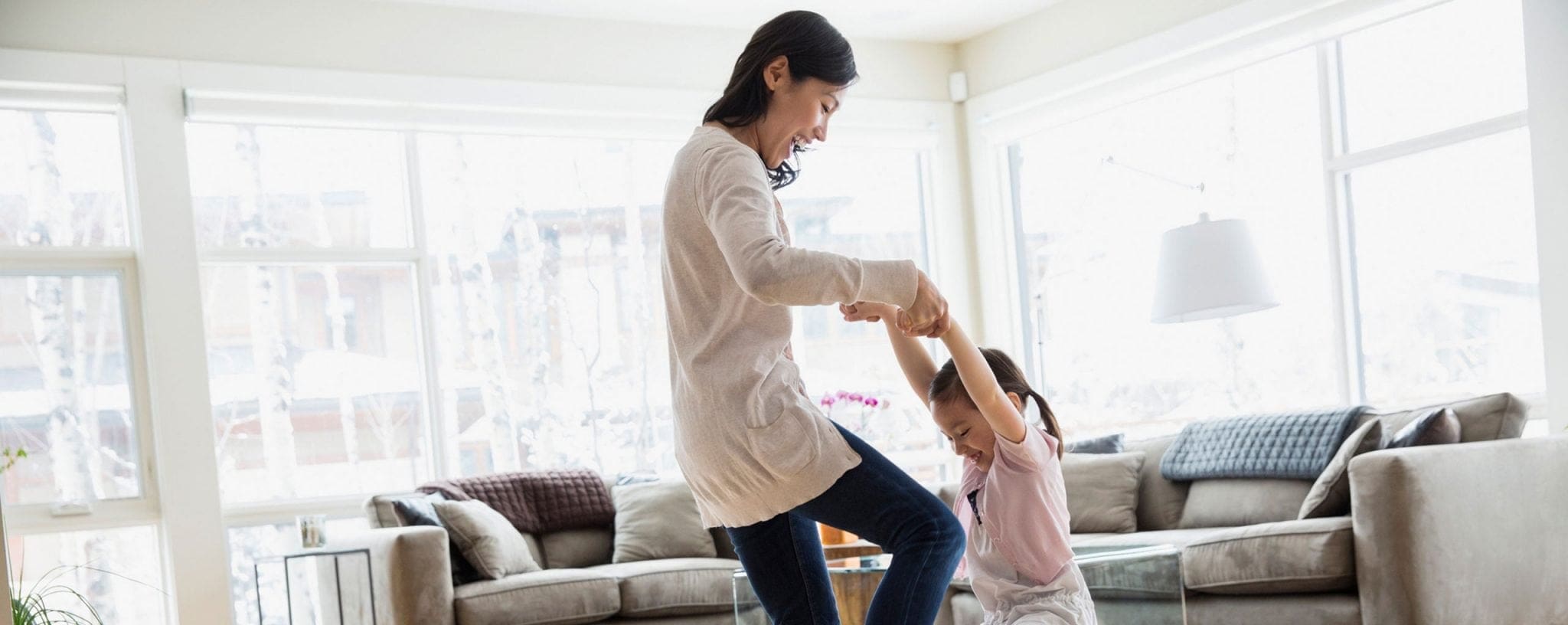 Mother playing with young child at home in the living room